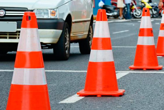 imagem de cones laranjas e carros passando ao lado