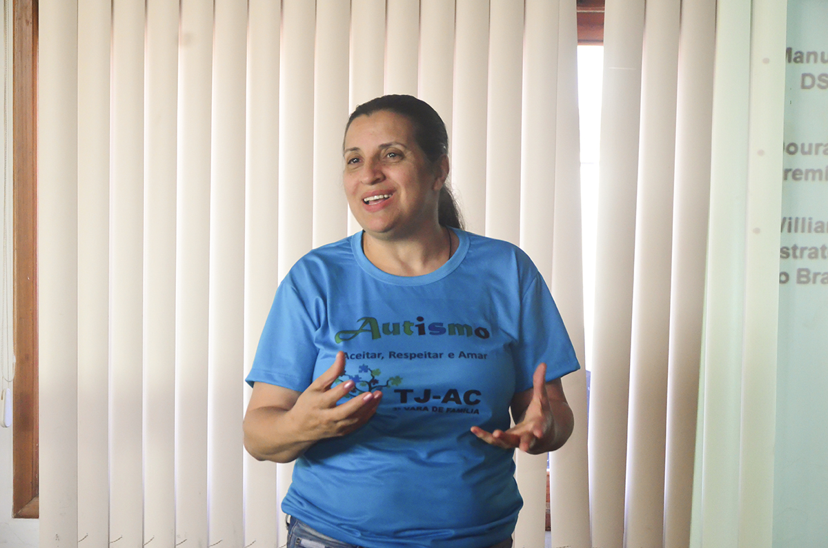 foto da ju[iza Maha gesticulando. Ela veste uma camiseta azul com frases sobre autismo