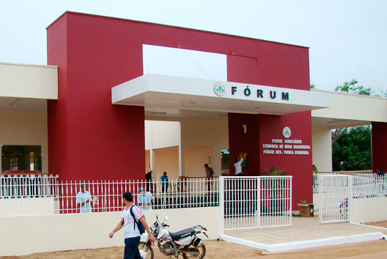 Fotografia da faixada do Fórum na cidade de Sena Madureira, com pessoas entrando e passando na frente do prédio