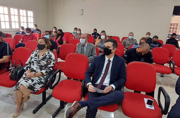 Auditório com cadeiras vermelhas e pessoas participantes da reunião da rede de proteção em Sena Madureira sentadas olhando para frente.