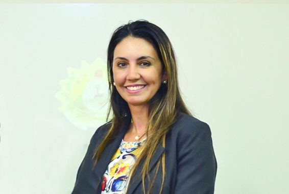 Foto da juíza Andréa Brito olhando na direção da câmera e sorrindo