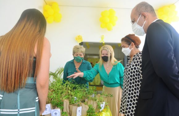 Presidente e vice-presidente do Tribunal de Justiça do Acre ao lado de três servidoras em volta da mesa com as mudas de plantas. Eles estão olhando para as plantas.