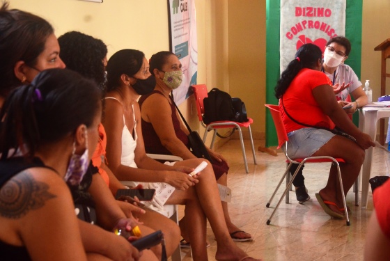 fila de mulheres esperando ser atendida e ao fundo a psicologa do TJAC atendendo uma pessoa