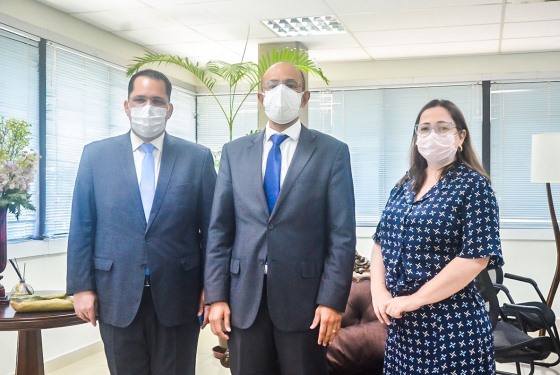 Foto do advogado Érick, do desembargador Roberto Barros e da advogada Marina de pé dentro do gabinete da presidência do TJAC