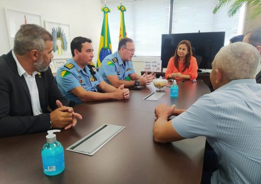 foto das autoridades militares e judiciárias sentadas em volta de uma mesa oval conversando. 