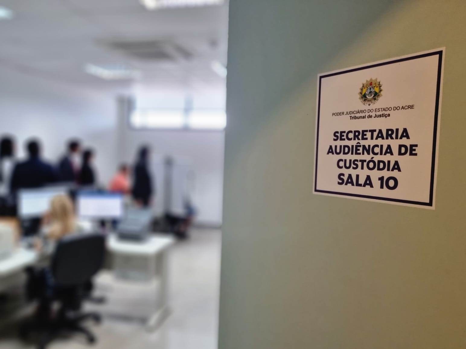 Foto da porta da sala com a placa indicando o local para fazer a biometria das pessoas detidas