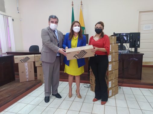 Foto da presidente e do corregedor entregando a caixa de computador para servidora