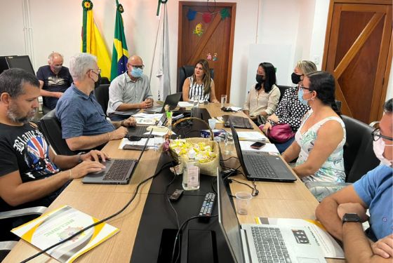 Foto de uma mesa de reunião com várias pessoas sentadas em volta