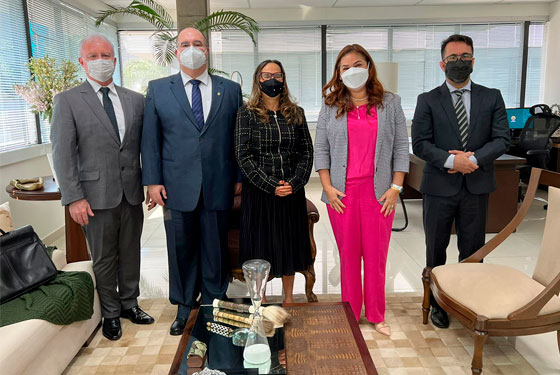 Foto das cinco pessoas em linha com máscaras olhando para foto