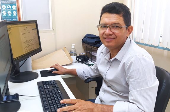 Servidor sentando na mesa com o novo computador a frente