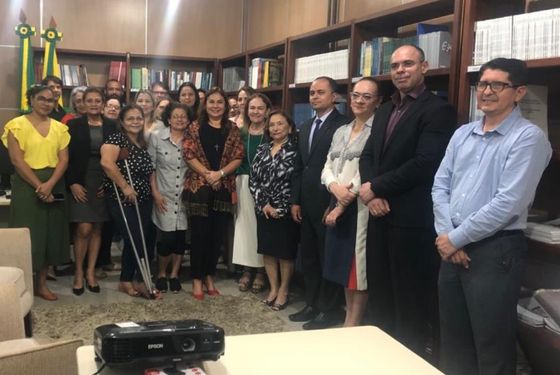 Diversas pessoas a frente de uma estante de livros