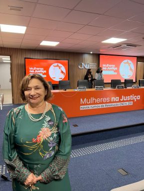 Fotografia da desembargadora Eva Evangelista no plenário do CNJ, onde está estampado o nome do evento "Mulheres na Justiça"