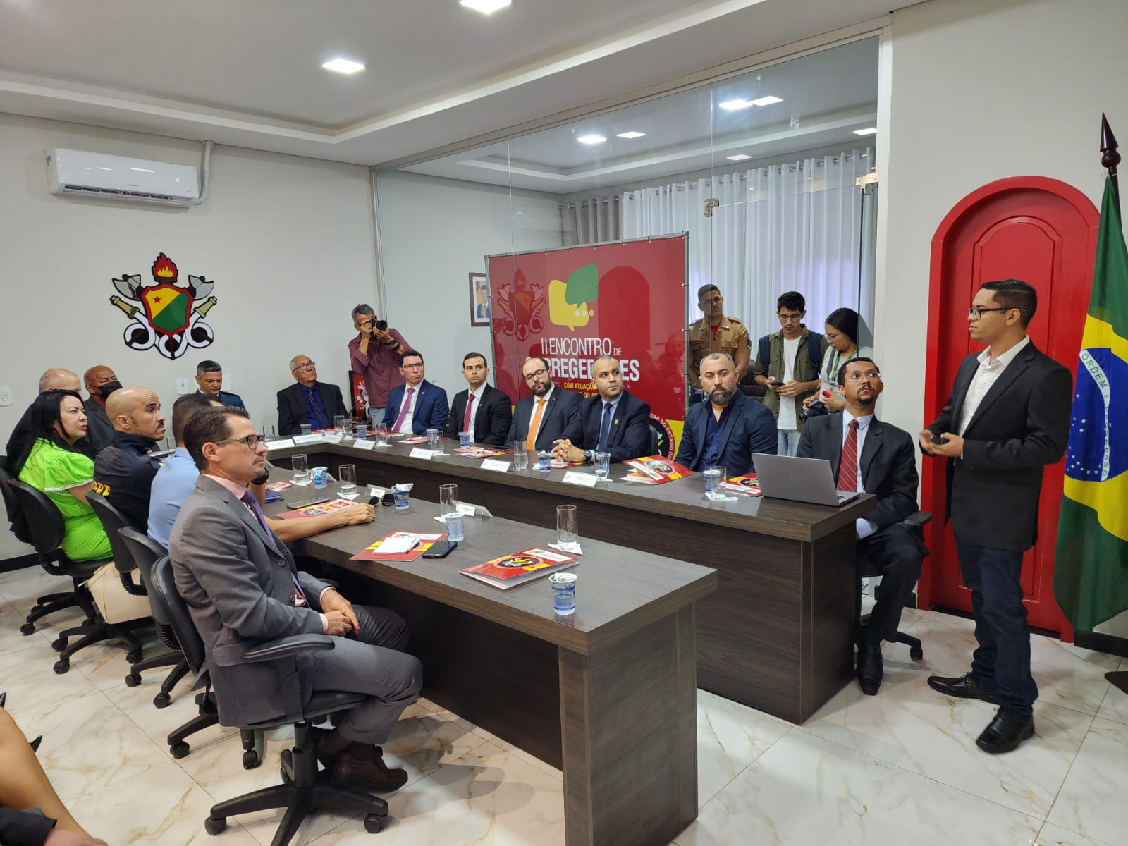 O servidor da Coger Josemar Mesquita em pé, apresentando sobre a automoção de procedimentos