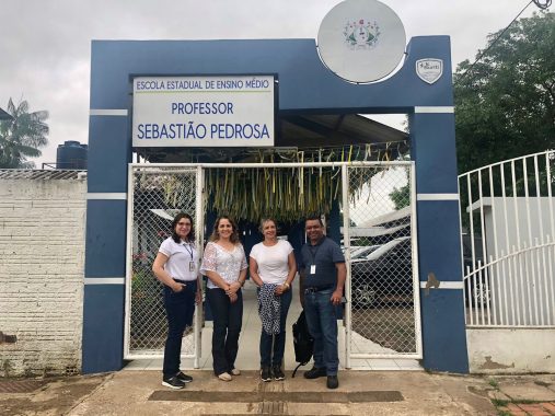 Fotografia de quatro servidores do TJAC na fachada da Escola Sebastião Pedrosa