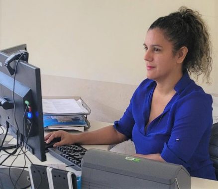 Servidora da Comarca de Manoel Urbano, à mesa, operando um dos novos computadores.
