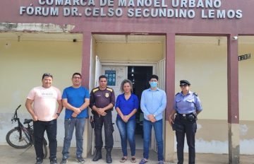 Servidores da Comarca de Manoel Urbano posam para foto na entrada do prédio.