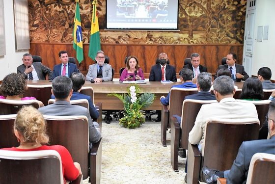 Numa bancada montada dentro do belíssimo auditório do Palácio da Justiça estão sentados a desembargadora-presidente e mais seis desembargadores do TJAC. Na plateia, estão magistrados e diretores da atual gestão.