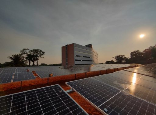Foto da usina fotovoltaica de Rio Branco, com o prédio do Fórum dos Juizados Especiais ao fundo das placas solares
