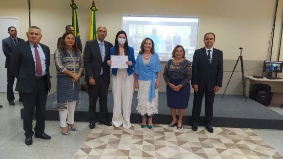 Fotografia da juiza substituta recebendo certificado de conclusão da formação inicial ofertada pela Esjud