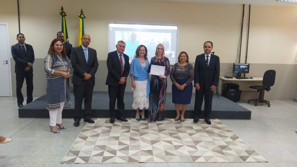 Fotografia da juiza substituta Glaucia Gomes recebendo certificado de conclusão da formação inicial ofertada pela Esjud