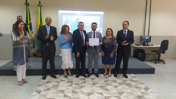 Fotografia do juiz substituto recebendo certificado de conclusão da formação inicial ofertada pela Esjud