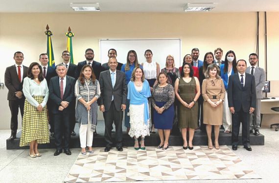 Pessoas em pé no auditório rindo para a foto