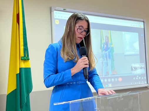 Fotografia da juíza substituta Rosilene Santana falando ao microfone no encerramento do curso da Esjud