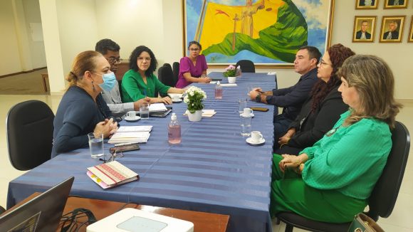 Fotografia da mesa de reunião, na qual estão representantes do TJAC, MPAC e defensoria pública