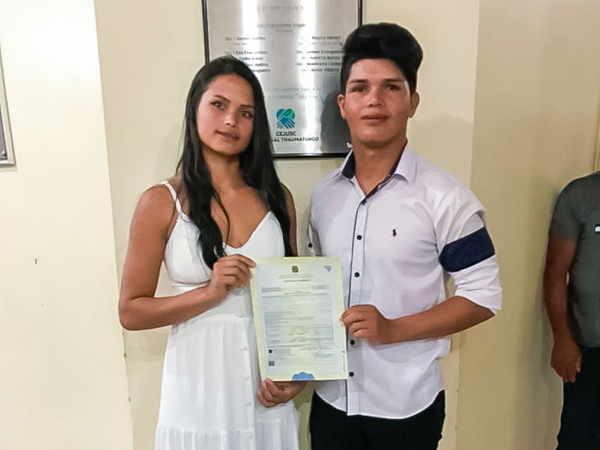 Casal mostrando a Certidão de Casamento