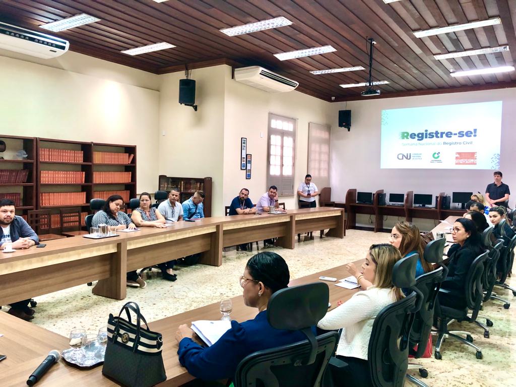 Foto da reunião preparatória do "Registre-se". Os representantes das instituições envolvidas estão assentados na mesa de reunião do Palácio da Justiça.