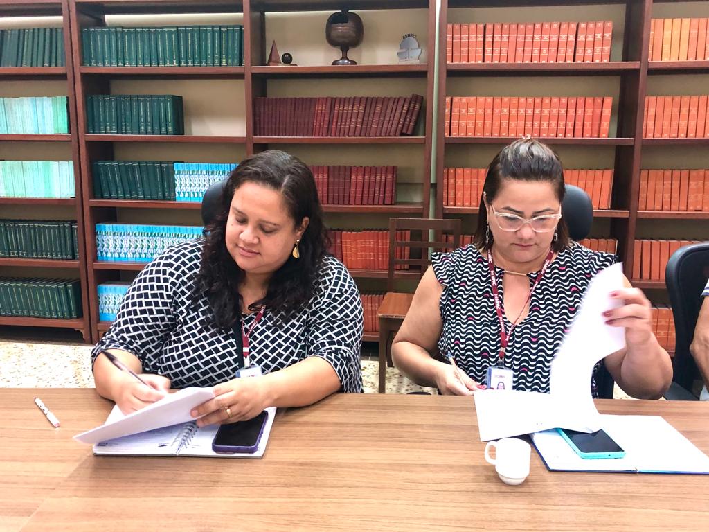 Foto de duas representantes do Ministério Público assinando o Termo de Compromisso de apoio ao evento "Registre-se"