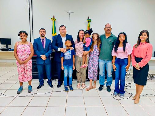 Fotografia do juiz, casal e crianças após o deferimento da guarda definitiva