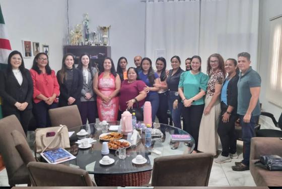 Todos o integrantes da reunião estão ladeados posando para foto.