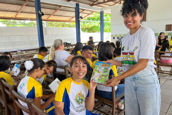 Alunos posam com as cartilhas recebidas.