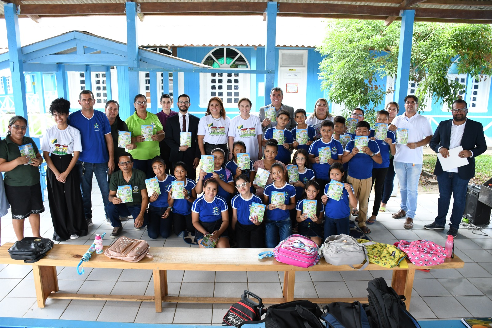 Os alunos posam para foto com as cartilhas recebidas nas mãos junto com as desembargadoras, magistrados e servidores.