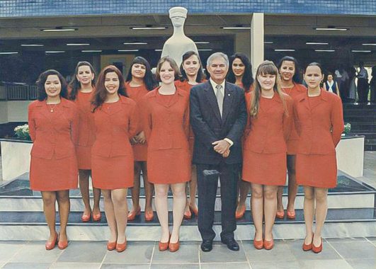 Foto da equipe de cerimonial e o desembargador Jersey Pacheco na reinauguração do Fórum Barão de Rio Branco. Todos estão a frente da estátua da deusa Themis