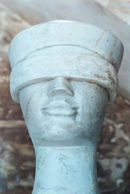 Fotografia aproximada da estátua da deusa Themis mostrando apenas detalhes do rosto, após ter sido esculpida em Minas Gerais