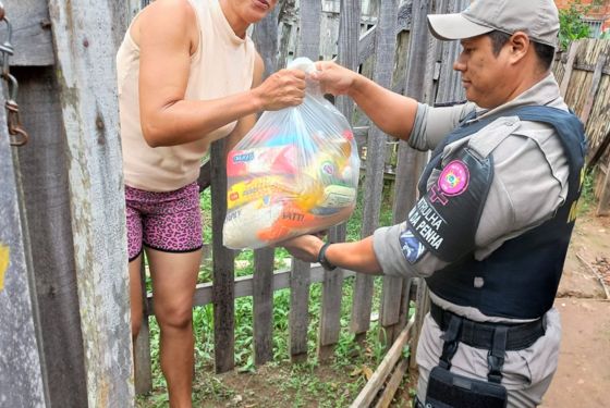 Policial Militar entregando cesta básica à vítima de violência doméstica.