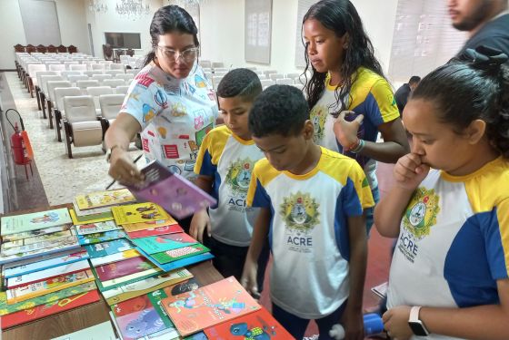 Alunos observando os livros disponíveis.