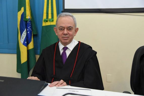Procurador de Justiça Celso Jerônimo posando para a fotografia na mesa do Tribunal Plenos