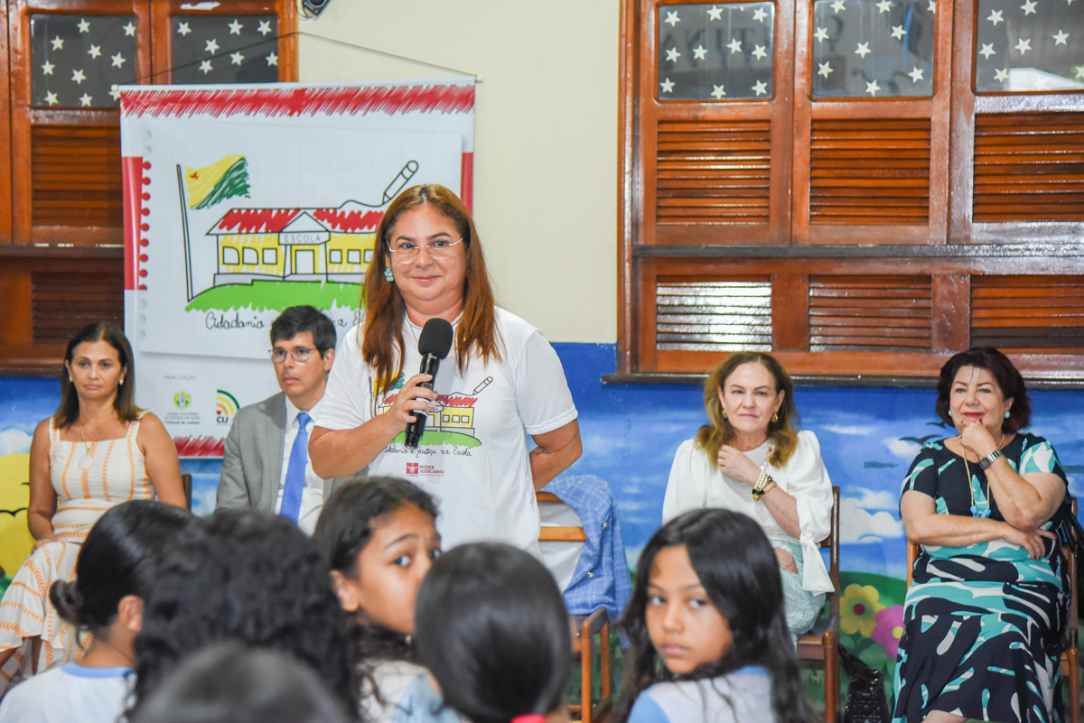 coordenadora da Infância e Juventude do tribunal de justiça do acre, desembargadora Waldirene Cordeiro, com microfone em mão, fala em solenidade de premiação do projeto Cidadania e Justiça na Escola