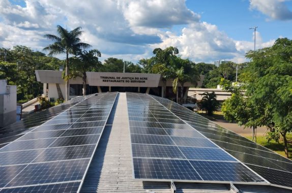 Foto de um dos telhados do TJAC com todos os painéis solares instalados. Ao fundo, aparece "Tribunal de Justiça do Acre. Restaurante do Servidor"