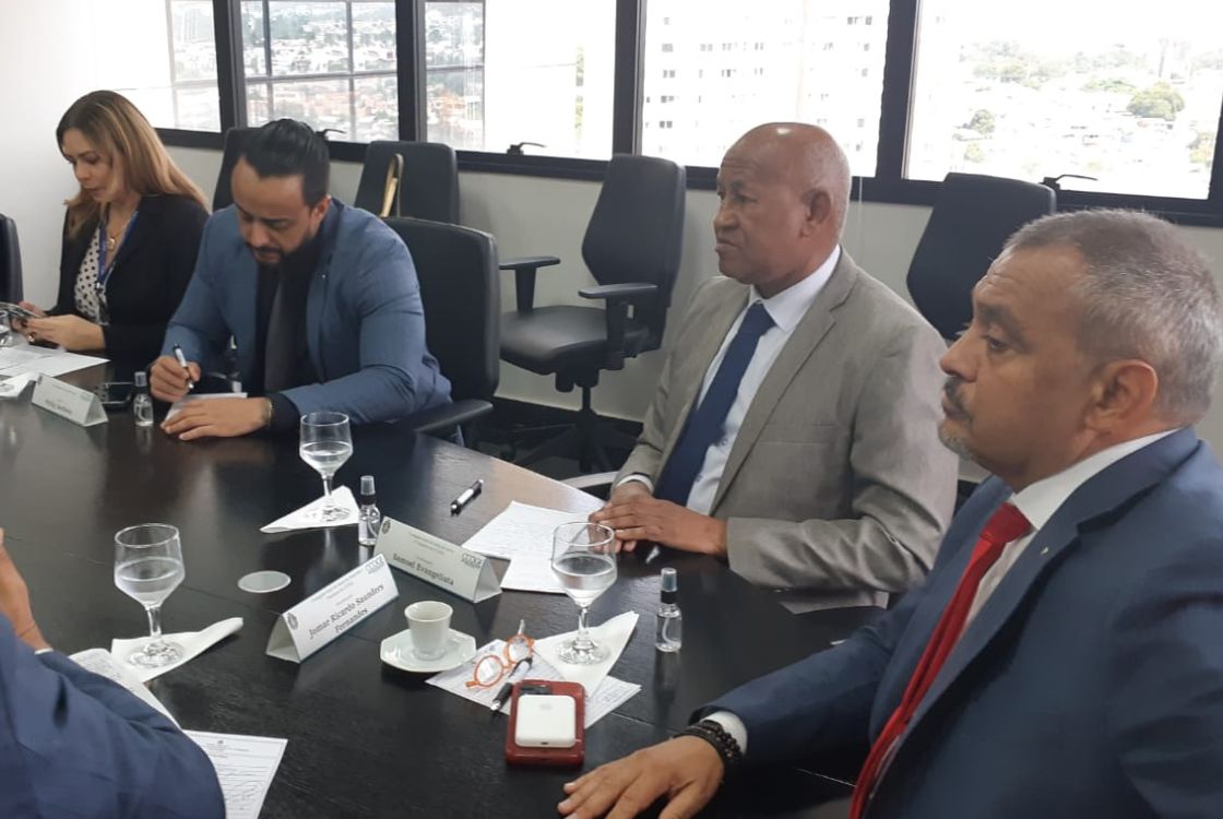 Foto do encontro de corregedores-gerais de Justiça da Região. Ao redor de uma mesa de cor preta, estão quatro homens e uma mulher.