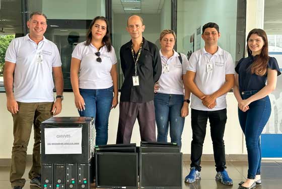 Imagem feita no átrio da sede administrativa do Tribunal, localizado na Capital do Estado do Acre, Rio Branco, rua Tribunal de Justiça, sem número, bairro Via Verde. Onde mostra representantes do Poder Judiciário Acreano doando computadores para representantes da Organização Nacional de Valorização da Vida, Educação e Saúde. TJAC doa computadores para capacitação de pessoas em vulnerabilidade social Oito equipamentos completos foram entregues à Organização Nacional de Valorização da Vida, Educação e Saúde, entidade socioassistencial O Tribunal de Justiça do Acre (TJAC), por meio da Presidência e da Diretoria de Informação e Comunicação (Ditec), realizou a doação de oito computadores à Organização Nacional de Valorização da Vida, Educação e Saúde (ONVVES). A entrega ocorreu na quinta-feira, 9, no átrio do edifício-sede do Judiciário acreano. Além dos computadores, a Justiça acreana doou periféricos e acessórios, como mouses, teclados e cabos de força e rede. Todos em pleno funcionamento e bom estado de conservação. De acordo com o servidor da Ditec, Cláudio Silva, “as máquinas podem ser utilizadas para diferentes serviços. E com certeza, vai ser bem utilizada pela Organização.”. A presidente da ONVVES, Karolayne dos Santos, agradeceu a doação do Judiciário acreano e ressaltou como os computadores serão úteis para prosseguir com o projeto social. “ A gente faz um trabalho nas comunidades, com pessoas em vulnerabilidade social. Então, essas máquinas são para facilitar o dia a dia dessa população, na geração de currículos e realização de cursos na área da informática. Fico muito agradecida de poder contar com o apoio do Tribunal de Justiça.”. Na solenidade, o servidor Cláudio Silva destacou a ação de destinação de equipamentos eletrônicos realizada pelo TJAC. “A iniciativa, além de oportunizar um ambiente mais limpo e sustentável, traz impacto positivo na sociedade, principalmente para os jovens e as crianças.”.